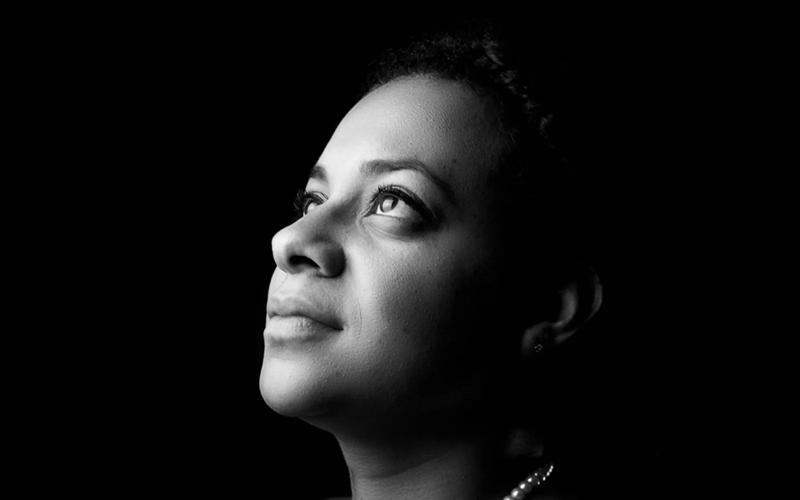 Retrato de una mujer iluminada de perfil sobre fondo negro